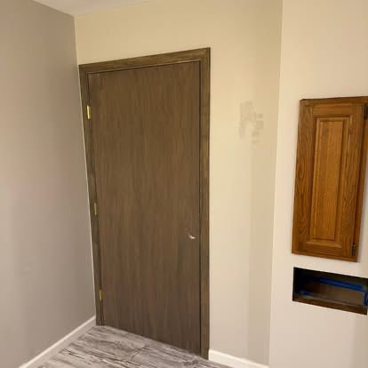 An interior wood door with fresh casing and trim, finished by Hughes Residential Services