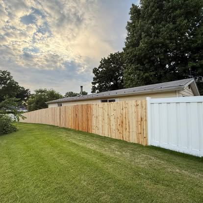 New wood privacy fence along a green backyard